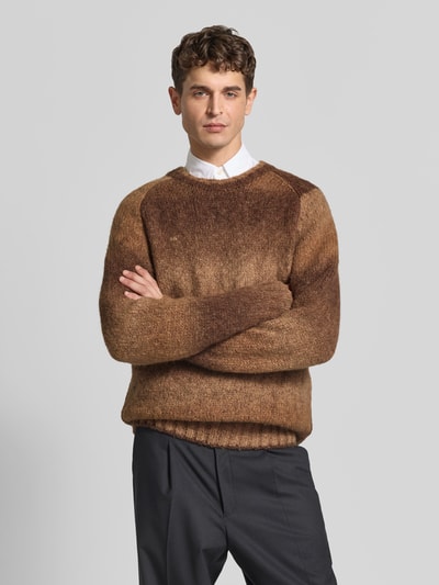 Männermodel trägt Pullover aus Woll-Mix von Forét in Brauntönen mit Rundhalsausschnitt und gerippten Abschlüssen, Ganzkörperansicht von vorne. Rückenlänge bei Größe M: 73 cm, gerader Schnitt, Raglanärmel.