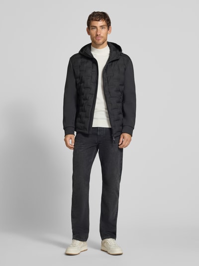 Männermodel trägt schwarze Regular Fit Steppjacke mit winddichter Funktion von Strellson, Herren Steppjacke, Ganzkörperansicht von vorne.
