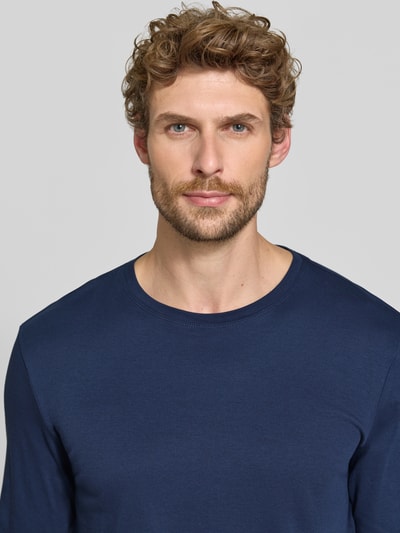Männermodel trägt Longsleeve aus reiner Baumwolle von Christian Berg Men in Dunkelblau, lockere Passform, Nahaufnahme Oberkörper.