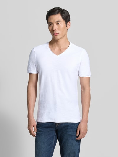Męski model nosi T-Shirt mit V-Ausschnitt von MCNEAL, krój regular fit, długość tyłu w rozmiarze M: 65 cm, całkowity widok z przodu.