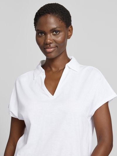 Frauenmodel trägt Regular Fit Poloshirt aus reiner Baumwolle von s.Oliver RED LABEL in Weiß, glatte Textur, Nahaufnahme Oberkörper.
