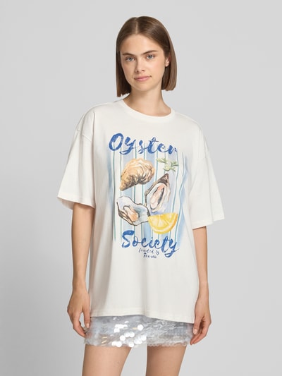 Vrouwenmodel draagt t-shirt met motiefprint van REVIEW in katoenmix met biologisch katoen, recht model, ronde hals, ruglengte maat S 68 cm. Ganzlichaamsvooraanzicht.
