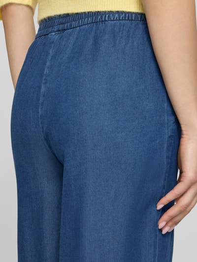 Frauenmodel trägt Relaxed Fit Culotte aus reinem Lyocell Modell 'CHARIS' von Only in Denim-Optik mit Elastisch-Bund und seitlichen Eingrifftaschen, Materialverarbeitung Popeline, Nahaufnahme Rückansicht.