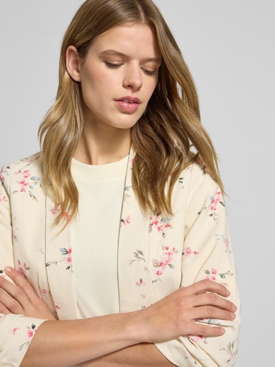 Vrouwenmodel draagt Regular Fit Longblazer met all-over motief model 'BOSELLA' van Pieces met reverskraag, 3/4-mouwen, schoudervullingen, geweven structuur. Detailopname bovenlichaam.