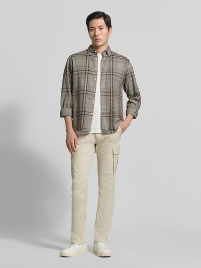 Männermodel trägt Regular Fit Cargohose aus bawełnianej mieszanki von s.Oliver RED LABEL, efekt: jednolity kolor, krój regular fit, proste nogawki, średni stan, naszywka z logo, nity, szlufki na pasek, wpuszczane kieszenie, kieszenie z tyłu, kieszenie cargo, Ganzkörperansicht von vorne.