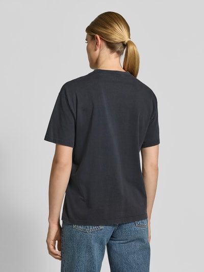 Vrouwenmodel draagt T-shirt met Labelstitching van Anine Bing, puur katoen, los model, ronde hals, ruglengte bij maat S 56 cm, geheel van achteren