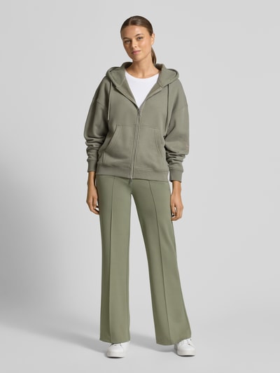 Frauenmodel trägt Hose mit Längsnähten und elastischem Bund von Smith and Soul im Material-Mix mit Viskose-Anteil, Regular-Fit, Bundweite bei Größe S 37 cm, Innenbeinlänge 80 cm, gerade Silhouette in hellem Oliv, feine glatte Oberfläche, Ganzkörperansicht von vorne.