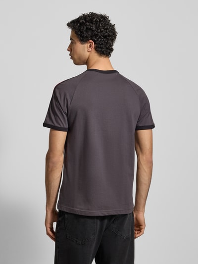 Männermodel draagt T-shirt met Labelstitching van adidas Originals in grijs, puur katoen, regular fit, ribboorden, ronde hals, ruglengte maat M 73 cm. Ganzkörperansicht Rückansicht.