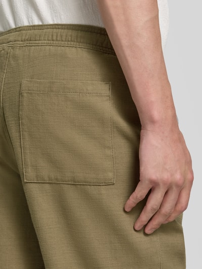 Männermodel trägt Shorts aus Baumwolle mit elastischem Bund von JAKE*S STUDIO MEN in Oliv, sichtbar strukturierte Textur, Detailaufnahme Rückansicht. Regular-Fit, elastischer Bund, Tunnelzug, Bundweite 47 cm, Innenbeinlänge 26 cm bei Größe M.