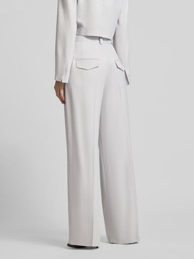 Frauenmodel trägt Weite Anzughose mit hoher Taille - curated by Vicky Heiler von SIC, helle Farbe, Wide Leg, Pattentaschen, Bügelfalten, Ganzkörperansicht Rückansicht.