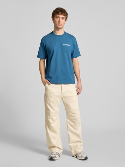 Männermodel trägt Relaxed Fit T-Shirt aus reiner Baumwolle mit Motiv-Print von Marc O'Polo Denim, Optik: Unifarben, Ganzkörperansicht von vorne