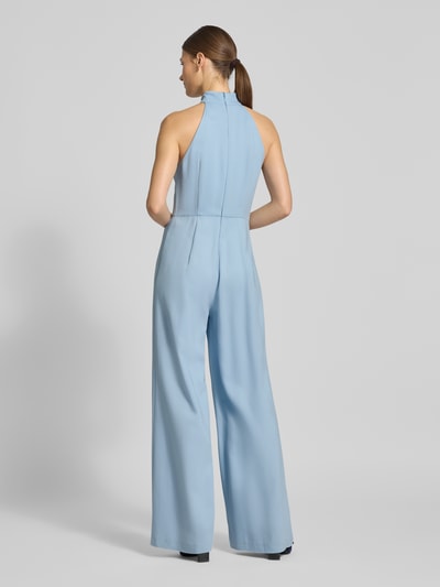 Frauenmodel trägt Jumpsuit mit Neckholder-Oberteil - curated by Vicky Heiler von SIC in Hellblau, ärmellos, tailliert, ausgestelltes Bein, Ganzkörperansicht Rückansicht.