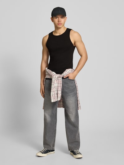 Mężczyzna model nosi czarny Tanktop mit Logo-Stitching Modell 'The Embroidery' von PROHIBITED, bawełniany materiał z dodatkiem stretchu, krój slim fit, prążkowana tekstura, dekolt okrągły, długość pleców w rozmiarze M: 56 cm, całopostaciowy widok z przodu.
