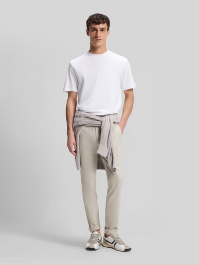 Männermodel trägt Slim Fit Chino aus Baumwoll-Mix mit Leinen und Viskose-Anteil von BOSS Orange in Denim-Optik, Twill, Ganzkörperansicht von vorne.