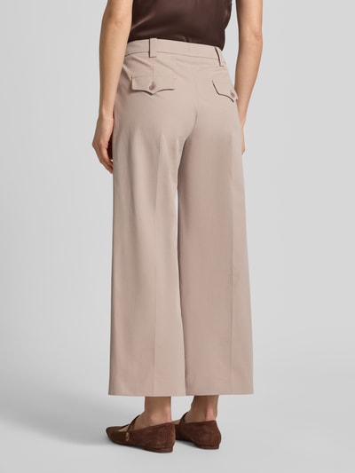 Frauenmodel trägt Slim Fit Hose mit Bügelfalten von Windsor im Baumwoll-Elasthan-Mix in Beige mit Gesäßtaschen, Ganzkörperansicht Rückansicht.