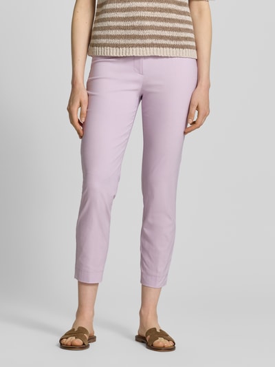 Frauenmodel trägt Slim Fit Stoffhose in verkürzter Passform von Christian Berg Woman aus elastischem Baumwoll-Mix in Flieder, Nahaufnahme Unterkörper.