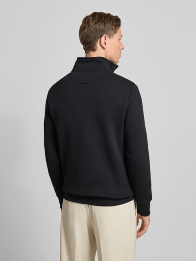 Männermodel trägt Sweatshirt mit Stehkragen und Reißverschluss von Gant, Baumwoll-Mix, schwarz, Regular Fit, Ganzkörperansicht Rückansicht.