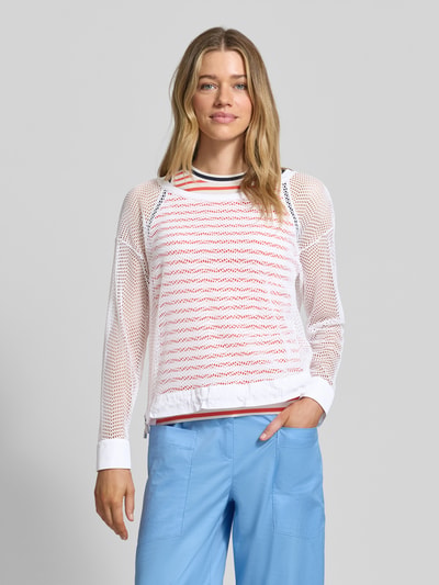 Frauenmodel trägt Longsleeve mit Lochmuster von Marc Cain, weiß, locker geschnitten, transparent, Rundhalsausschnitt, Ganzkörperansicht von vorne.