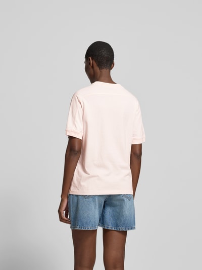 Frauenmodel trägt Regular Fit T-Shirt mit Logo-Print von Anine Bing aus reiner Baumwolle, hellrosa Farbton, Ganzkörperansicht Rückansicht.