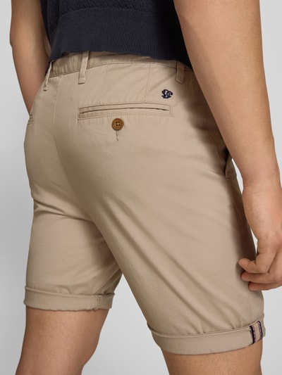 Männermodel trägt Regular Fit Shorts mit Münztasche von Superdry in Beige, Baumwoll-Mix, Gesäßtasche, Knopf-Reißverschluss, Ganzkörperansicht Rückansicht.