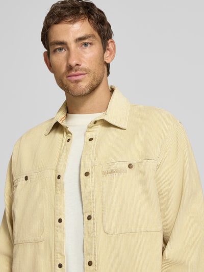 Männermodel trägt Regular Fit Freizeithemd mit Brusttaschen Modell 'LAVVU' von Napapijri in Beige, reine Baumwolle, Nahaufnahme Oberkörper.
