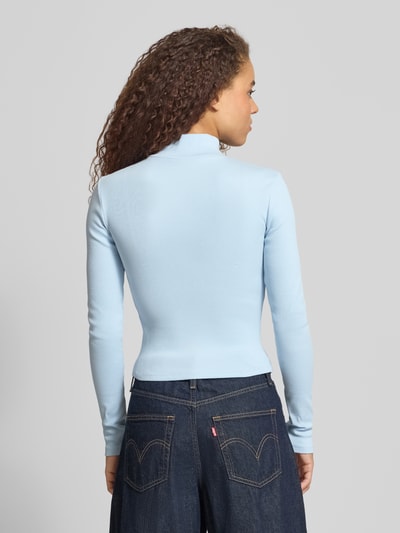 Frauenmodel trägt Slim Fit Jacke mit Stehkragen von Gina Tricot in Hellblau, elastischer Baumwoll-Mix, Rückenlänge 50 cm, Ganzkörperansicht Rückansicht.