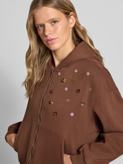 Vrouwenmodel draagt Sweatjacke mit Kapuze Modell 'TRUFFLE' van DAISY STREET, katoen, relaxed fit, knopen, ritssluiting, kangoeroezak, detailopname bovenlichaam.