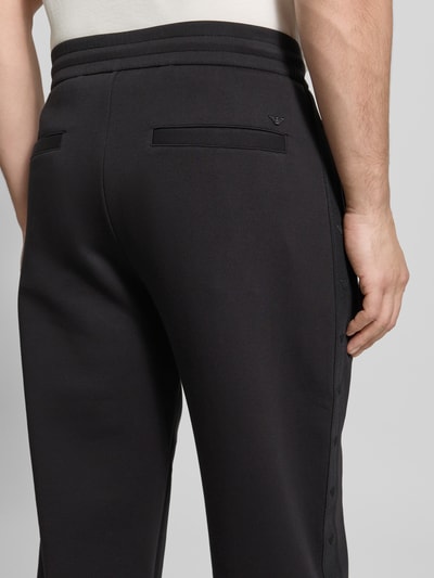 Männermodel trägt Regular Fit Sweathose mit Label-Details von Emporio Armani, schwarze Farbe, Baumwoll-Mix, Rückansicht Nahaufnahme.