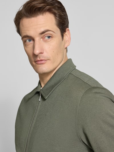 Männermodel trägt Jacke mit Umlegekragen und Reißverschluss von Lindbergh in Olivgrün, Material-Mix, Nahaufnahme Oberkörper.