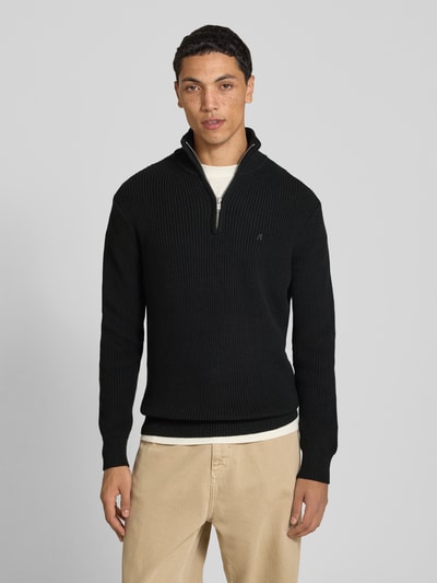 Männermodel trägt Slim Fit Pullover aus reiner Baumwolle in Strick-Optik von Replay, schwarze Farbe, Ganzkörperansicht von vorne.