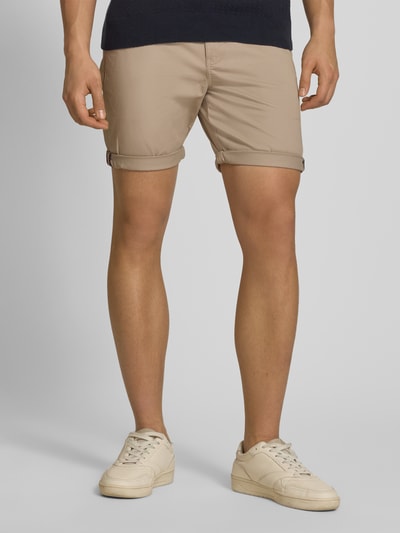 Männermodel trägt Regular Fit Shorts mit Münztasche von Superdry in Beige, Baumwoll-Mix, Seitentaschen, Knopf-Reißverschluss, Nahaufnahme Oberschenkel.