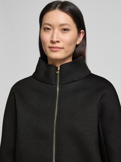 Frauenmodel trägt Blazer aus Viskose-Mix mit Stehkragen von Rinascimento in Schwarz mit Reißverschluss, Nahaufnahme Oberkörper.
