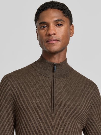Männermodel trägt Regular Fit Strickpullover aus Schurwolle von Emporio Armani in Braun mit feinen diagonalen Linien, Nahaufnahme Oberkörper. Herren Strickpullover, reine Schurwolle, normale Passform, Troyer-Kragen, elastische Abschlüsse.