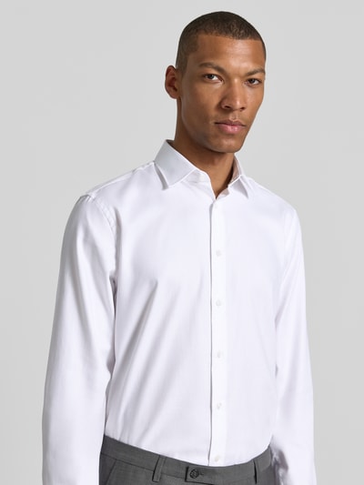 Männermodel trägt Slim Fit Business-Hemd mit Kentkragen von Jake*s aus Reine Baumwolle, Knopfleiste, Sportmanschetten, Nahaufnahme Oberkörper.