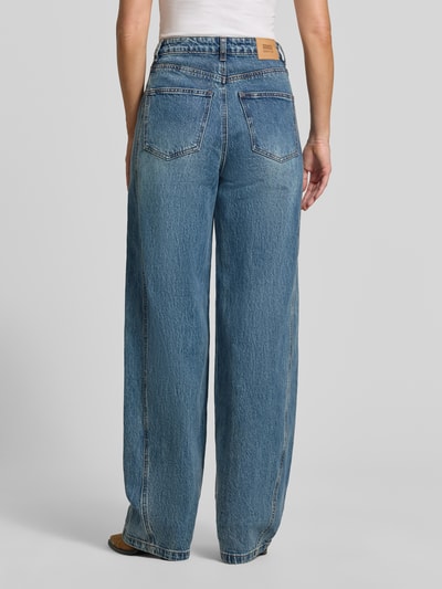 Frauenmodel trägt Barrel Fit Jeans aus Baumwoll-Mix Modell 'Melu' von GESTUZ, mittleres Blau, 5-Pocket, Ganzkörperansicht Rückansicht. Baumwoll-Elasthan-Mix, Knopf- und Reißverschluss, Bundweite 39 cm, Innenbeinlänge 86 cm.