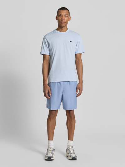 Männermodel trägt Regular Fit T-Shirt aus Baumwoll-Mix von Lacoste, Optik: Unifarben, Logo-Applikation, Rundhals, Kurzarm, schnelltrocknend, Ganzkörperansicht von vorne