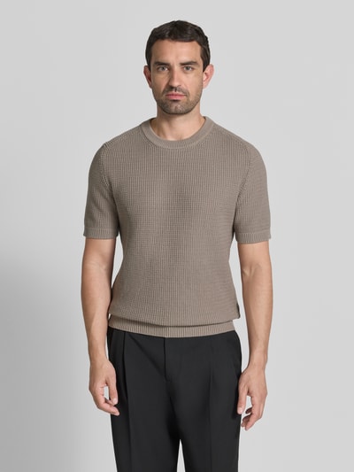 Männermodel trägt Relaxed Fit Strickpullover aus reiner Baumwolle Modell 'SAFFON' von HUGO in Beige, Waffelstrick, Nahaufnahme Oberkörper.
