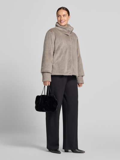 Frauenmodel trägt czarną torebkę Handtasche aus echtem Leder Modell 'NOELLE' od Abro z imitacją futra, Główna przegroda z zapięciem na magnes, cienki pasek na ramię, długie uchwyty, wewnątrz dwie przegródki zapinane na zamek błyskawiczny, Szerokość w rozmiarze 1: 28 cm, długość w rozmiarze 1: 20 cm, głębokość w rozmiarze 1: 15 cm, długość paska na ramię w rozmiarze 1: 38 cm, Ganzkörperansicht von vorne