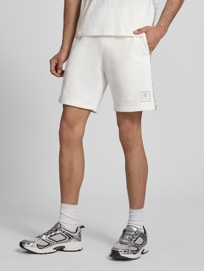 Männermodel trägt Shorts mit Logo und elastischem Bund von CHAMPION, Baumwoll-Mix in Weiß, Regular Fit, Nahaufnahme Oberschenkel, Vorderansicht.
