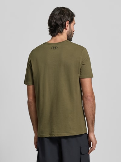 Męski model trägt Regular Fit T-Shirt mit Logo-Print Modell 'Left' von Under Armour, mieszanka bawełny, okrągły dekolt, długość tyłu 72 cm, Ganzkörperansicht Rückansicht.