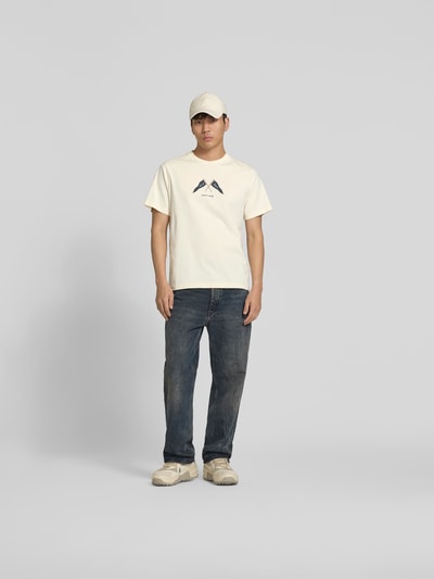 Männermodel trägt Regular Fit T-Shirt mit Logo-Print von Forét in Offwhite, reine Baumwolle, Rundhalsausschnitt, Ganzkörperansicht von vorne.
