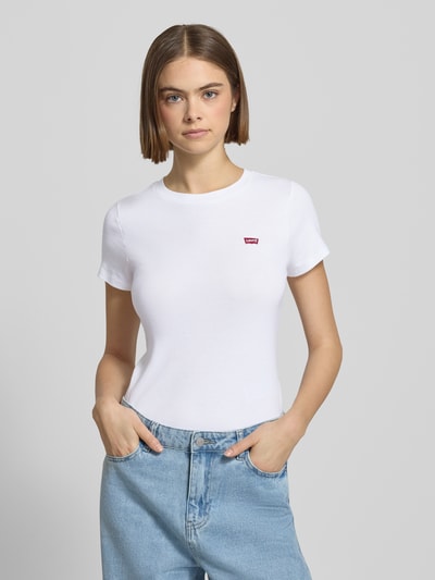 Kobiece modelka nosi T-Shirt z label-detail w 2er-pack od Levi's®, biały kolor, slim fit, bawełna, okrągły dekolt, z przodu, ujęcie całej sylwetki.