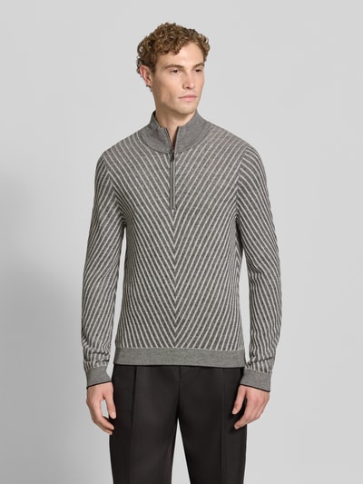 Männermodel trägt Regular Fit Strickpullover aus Schurwolle von Emporio Armani in Grau mit geometrischem Muster, Ganzkörperansicht von vorne. Rückenlänge bei Größe M 66 cm, Ärmellänge 71 cm, Troyer-Kragen, elastische Abschlüsse, reine Schurwolle, normale Passform.
