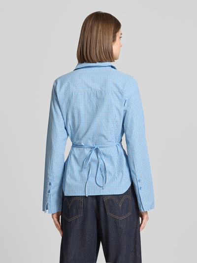 Vrouwenmodel draagt Regular Fit blouse met strikceintuur model 'CARO' van JJXX, materiaalmix met katoen, ruglengte maat S 64 cm, mouwlengte maat S 64 cm, ruitjesmotief in lichtblauw en wit, detailtextuur zichtbaar, ganzkörperansicht rückansicht.