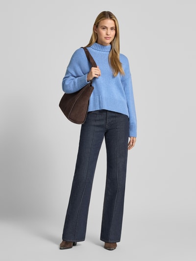 Frauenmodel trägt Relaxed Fit Pullover aus Schurwoll-Mix in Strick-Optik von Lanius in Hellblau, Rollkragen, Kombination mit dunkler Jeans, strukturierte Strick-Textur, Damen Pullover mit Baumwoll-Anteil, Ganzkörperansicht von vorne.