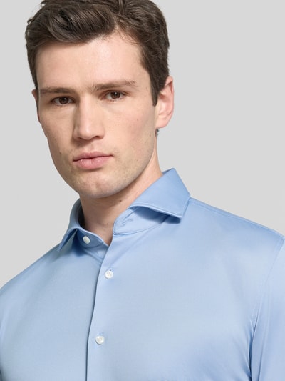Männermodel trägt Slim Fit Businesshemd aus atmungsaktivem Material Modell 'P-HANK-SPREAD' von BOSS in Hellblau, Nahaufnahme Oberkörper.