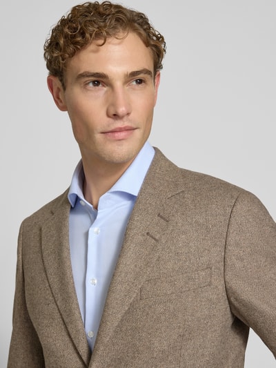 Männermodel trägt Slim Fit Sakko aus reiner Viskose Modell 'Justin' von Tiger of Sweden in Beige mit Reverskragen, Nahaufnahme Oberkörper.