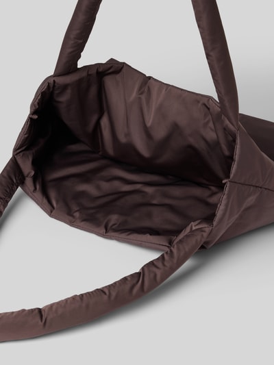 Produktfoto, braune Tote Bag mit Logo-Detail Modell 'Puffy' von Studio Noos mit wattierten Schulterriemen und offenem Hauptfach, weiche glatte Textur, Kontexthinweis: Maße 58x42x9 cm, Länge Schulterriemen 74 cm