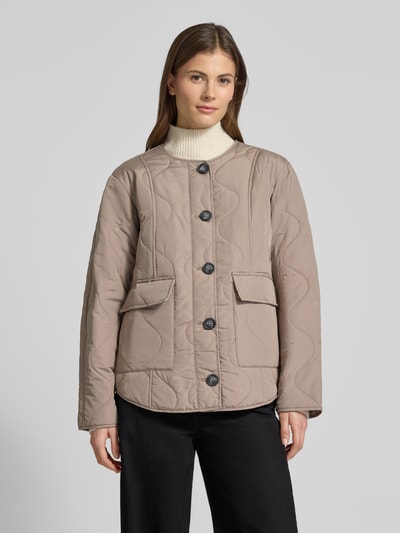 Vrouwenmodel draagt Regular Fit Steppjacke mit Pattentaschen Modell 'MILLIE' van Vero Moda, effen, zonder kraag, lange mouwen, knoopsluiting, doorgestikt, met klepzakken. Vooraanzicht bovenlichaam.