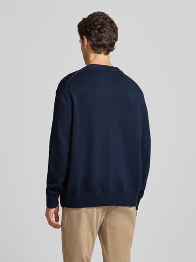 Männermodel trägt Regular Fit Cardigan aus reine Baumwolle von Selected in Dunkelblau, unifarben, gerippte Abschlüsse, Ganzkörperansicht Rückansicht.